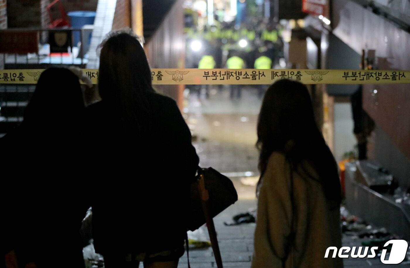 본문 이미지 - 29일 밤 서울 용산구 이태원 한복판에서 심정지 환자가 대규모로 발생했다. 3년 만에 첫 '야외 노마스크' 핼러윈을 맞아 인파가 몰리면서 대규모 압사사고가 일어난 것으로 추정된다. 소방청은 이날 오후 11시13분 이태원에서 압사 추정 사고가 발생함에 따라 대응 3단계로 격상한다고 밝혔다. 사진은 30일 사고가 발생한 서울 용산구 이태원에서 시민들이 사고현장을 바라보는 모습. 2022.10.30/뉴스1 ⓒ News1 장수영 기자