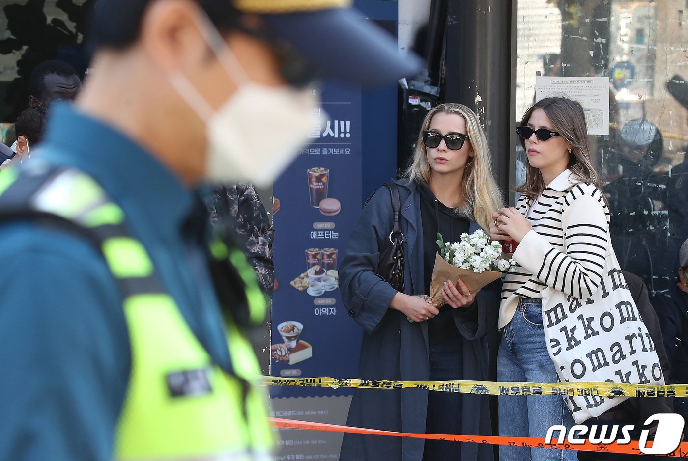 30일 오후 서울 용산구 이태원 압사 사고 현장 인근에서 외국인들이 추모를 위해 꽃을 들고 있다. 이태원 압사사고로 발생한 인명피해는 이날 현재 사망 151명, 중상 19명, 경상 63명이다. 2022.10.30/뉴스1 ⓒ News1 임세영 기자