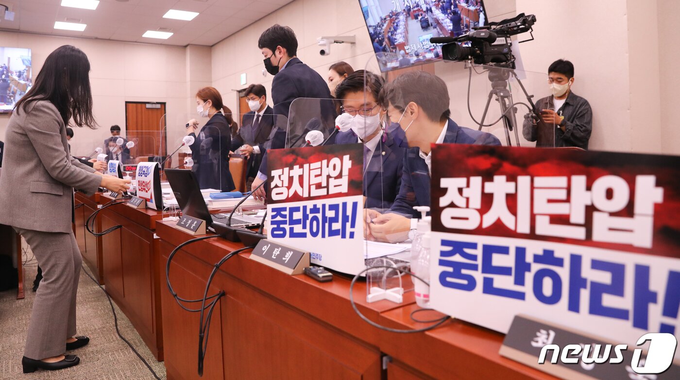 본문 이미지 - 4일 서울 여의도 국회에서 열린 대법원 등에 대한 법제사법위원회 국정감사에서 더불어민주당 의원석에 '정치탄압 중단하라' 피켓을 노트북에 붙이자 국민의힘도 의원석에 민생 국감 촉구 피켓을 붙이고 있다. 2022.10.4/뉴스1 ⓒ News1 허경 기자