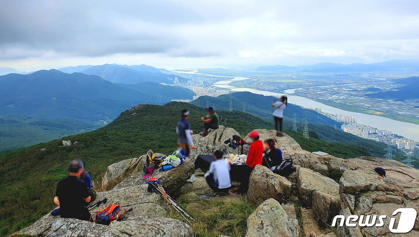 본문 이미지 - 고당봉 풍경2. 정상석 남쪽에서 금정산과 낙동강, 김해 벌판을 바라보는 사람들. 낙동강이 바다로 들어가는 모습이 비장하다.