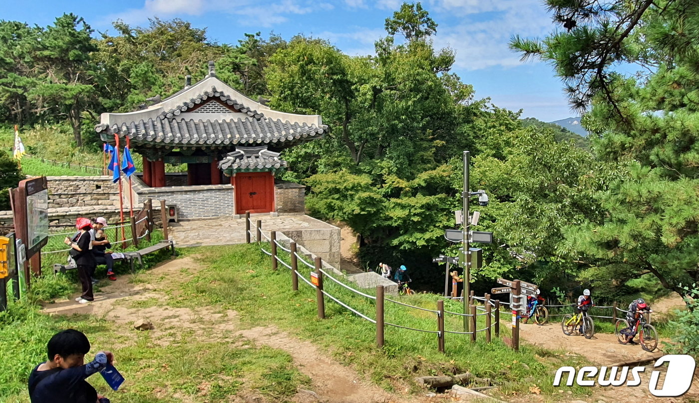 동문 풍경. 오른쪽에 산악자전거 단체가 등산로로 오르고 있다. 산악자전거는 바닥이 단단한 임도에서만 타야 한다.