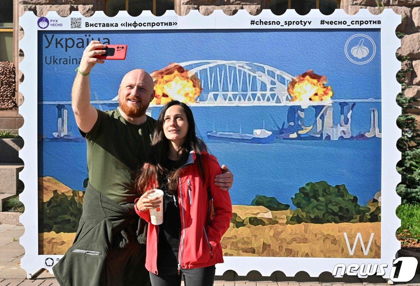 8일&#40;현지시간&#41; 한 커플이 크름대교 폭발 기념 우표 도안 앞에서 기념촬영을 하고 있다. ⓒ AFP=뉴스1 ⓒ News1 박형기 기자