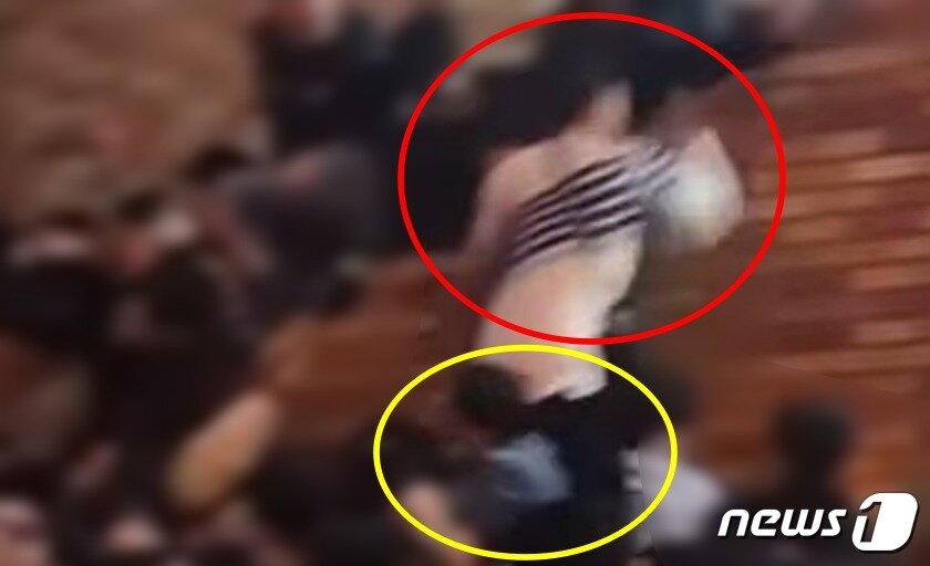 본문 이미지 - '이태원 의인'으로 지목된 청재킷을 입은 남성(노란색 원)이 BJ 배지터(빨간색 원)가 난간 위로 탈출하도록 자신의 어깨를 내어 주고 있다.(온라인 커뮤니티 갈무리)