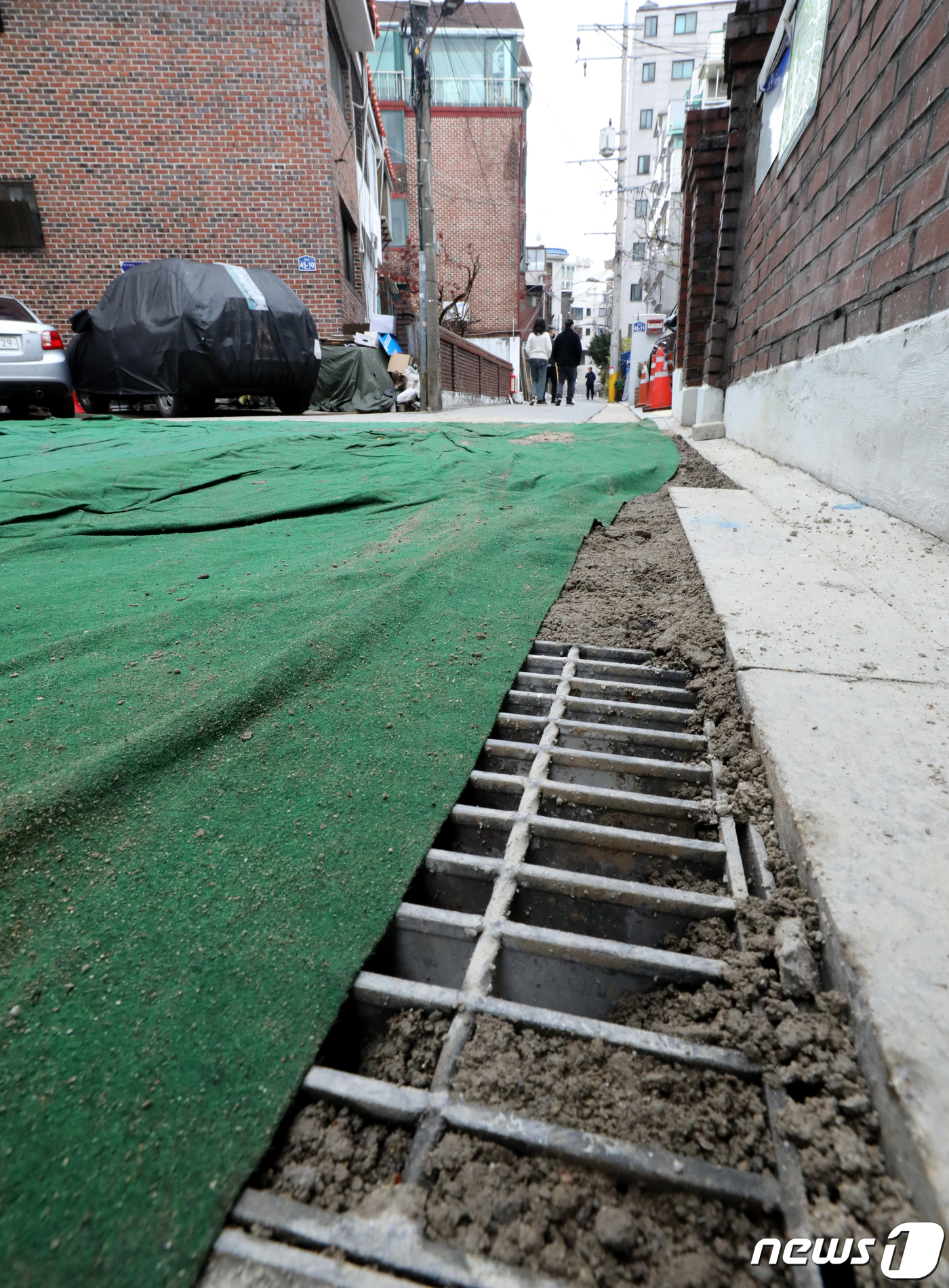 (서울=뉴스1) 장수영 기자 = 13일 서울 은평구에 위치한 침수피해 발생 가구 앞 도로가 비포장된 상태로 천이 덮혀 있다.침수피해가 발생한 지역 일대는 하수시설물 보수공사가 진행 …