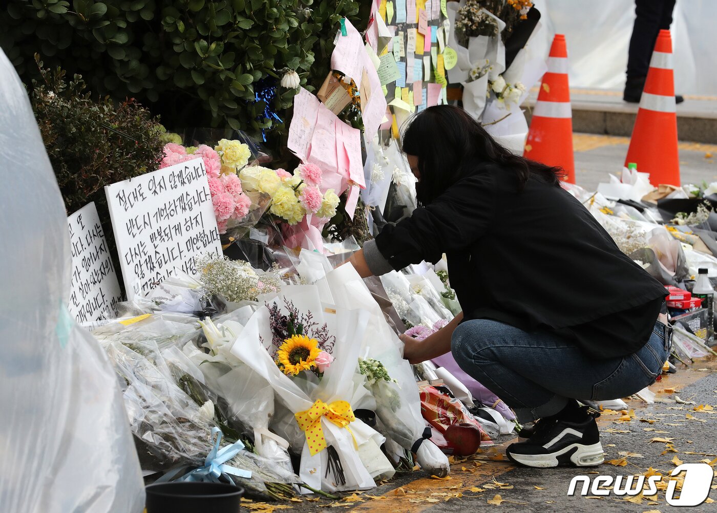 본문 이미지 - 13일 오전 서울 용산구 이태원역 1번 출구에 마련된 이태원 참사 희생자 추모공간에서 자원봉사자가 현장 정리를 하고 있다. 2022.11.13/뉴스1 ⓒ News1 김진환 기자