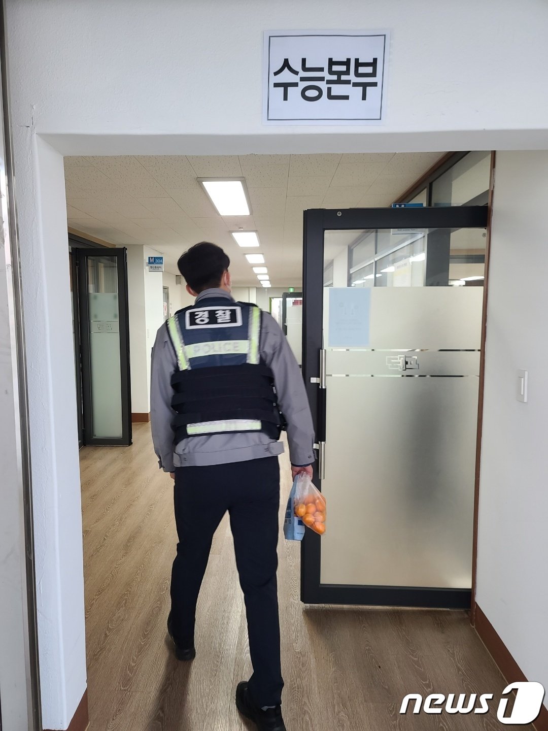 본문 이미지 -  경찰이 부모를 대신해 간식과 손목시계를 수능본부 사무실에 전달하는 모습.(부산경찰청 제공)