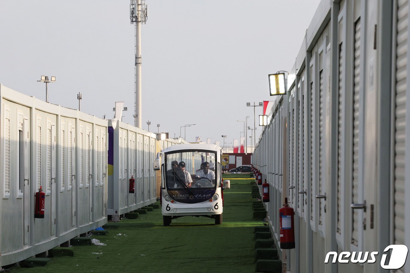 본문 이미지 - 2022카타르 월드컵 개막을 사흘 앞둔 17일(현지시간) 카타르 도하 하마드 국제공항 인근에 조립식 컨테이너 형태로 조성된 '팬 빌리지'에서 관계자들이 버기카를 타고 이동하고 있다. 개최국 카타르가 관광객을 수용하기 위해 마련한 임시 숙소가 비싼 가격에 비해 시설은 열악하다는 지적을 받고 있다. 숙박비는 1박에 200달러(약 27만 원), 식사를 포함할 경우 270달러(약 36만 원)이다.2022.11.17/뉴스1 ⓒ News1 이광호 기자