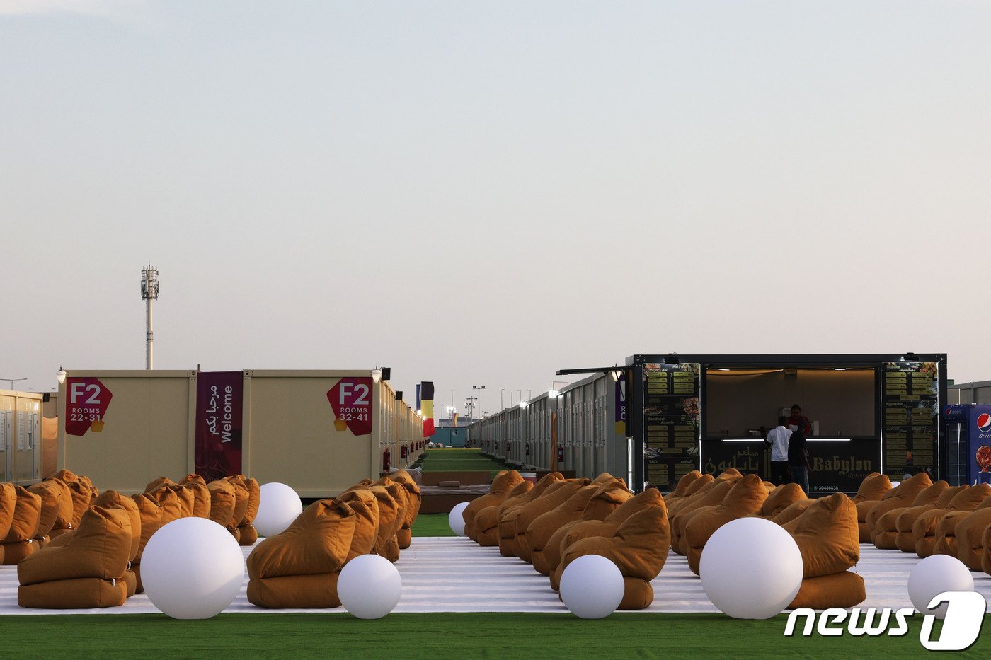 본문 이미지 - 2022카타르 월드컵 개막을 사흘 앞둔 17일(현지시간) 카타르 도하 하마드 국제공항 인근에 조립식 컨테이너 형태로 조성된 '팬 빌리지'의 야외 축구 관람 시설 모습. 개최국 카타르가 관광객을 수용하기 위해 마련한 임시 숙소가 비싼 가격에 비해 시설은 열악하다는 지적을 받고 있다. 숙박비는 1박에 200달러(약 27만 원), 식사를 포함할 경우 270달러(약 36만 원)이다.2022.11.17/뉴스1 ⓒ News1 이광호 기자