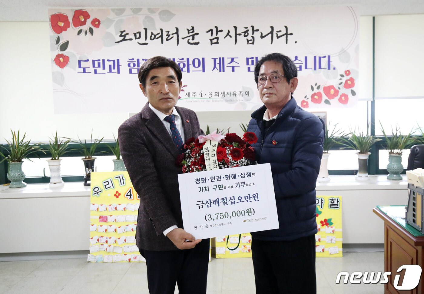 본문 이미지 - 제주4·3 희생자 유족인 한하용 씨(오른쪽)가 18일 오전 제주시 봉개동 제주4·3유족회 사무실에서 오임종 제주4·3유족회장에게 국가보상금을 처음으로 기부하고 있다. 2022.11.18/뉴스1 ⓒ News1 오현지 기자