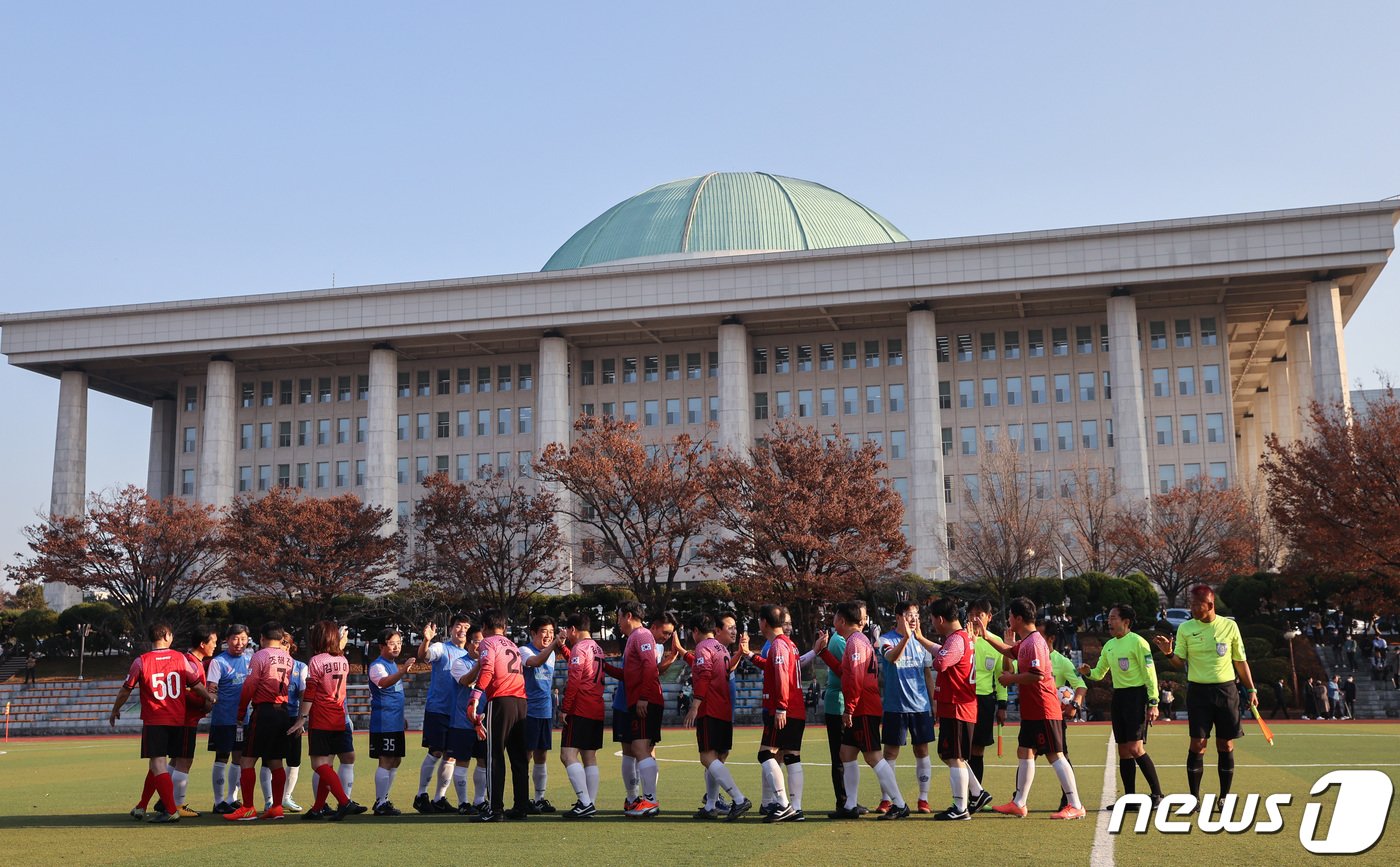 18일 오후 서울 여의도 국회 운동장에서 열린 여야 국회의원 친선 축구 경기에 앞서 의원들이 인사를 하고 있다. 2022.11.18/뉴스1 ⓒ News1 이재명 기자