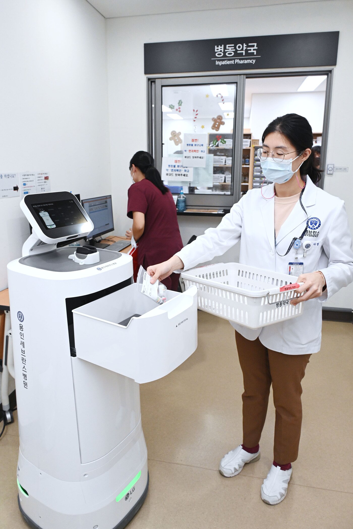 본문 이미지 - 의료진이 LG 클로이 서브봇에 의약품을 담고 있다(LG전자 제공).