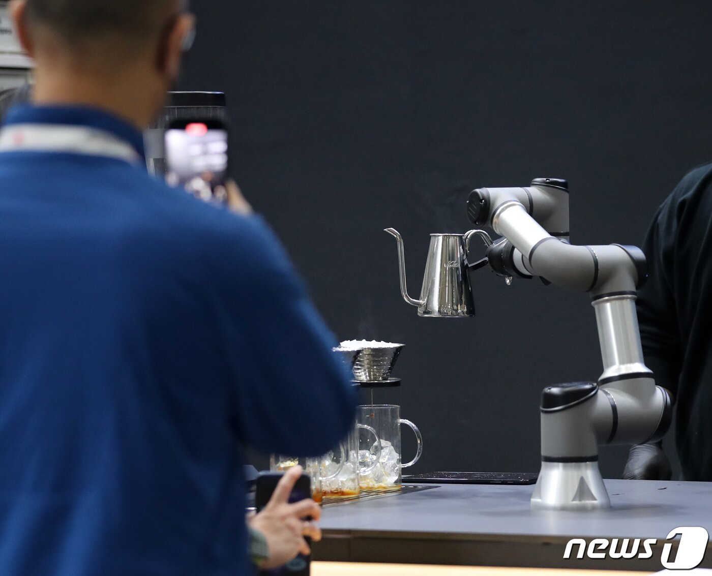 본문 이미지 - 서울 강남구 코엑스에서 열린 제21회 서울카페쇼에서 한 관람객이 커피를 제조하는 로봇을 스마트폰으로 촬영하고 있다. /뉴스1 ⓒ News1 김진환 기자