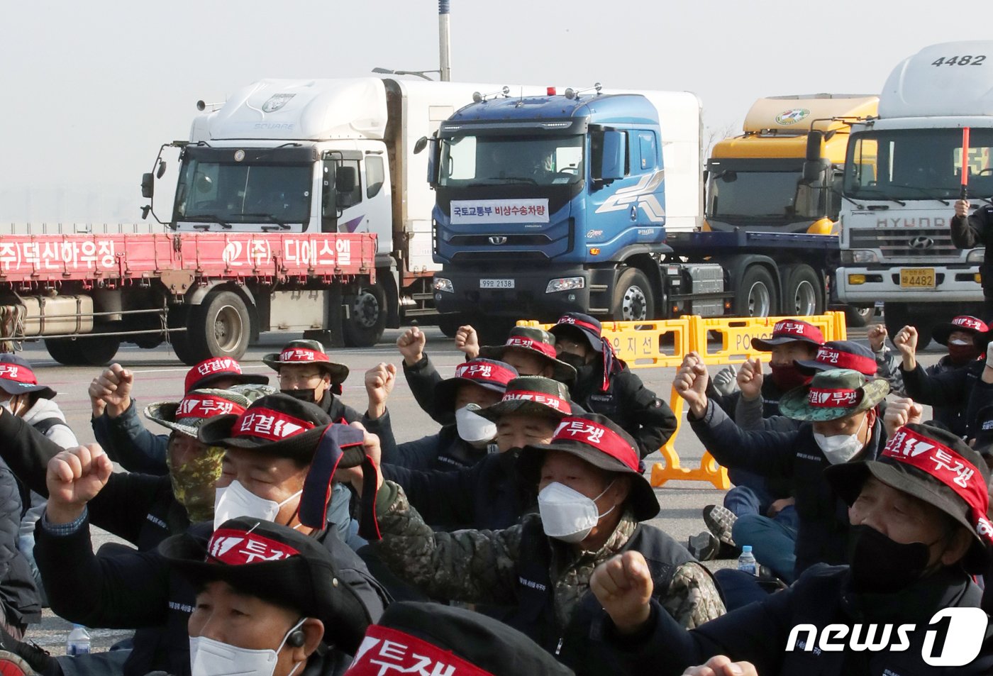 민주노총 공공운수노조 화물연대본부가 무기한 총파업에 돌입한 24일 오전 인천시 연수구 선광신항 앞에 국토교통부 비상수송차량이 화물연대 파업 출정식 앞을 지나가고 있다. 2022.11.24/뉴스1 ⓒ News1 정진욱 기자