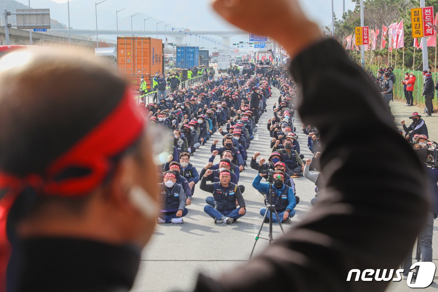 본문 이미지 - 민주노총 공공운수노조 화물연대본부가 무기한 총파업에 돌입한 24일 오전 부산 강서구 부산신항 인근에서 화물연대 조합원들이 구호를 외치고 있다. 화물연대는 이날부터 서울, 경기, 인천 등 전국 16개 본부에서 안전운임제 일몰제 폐지, 안전운임 차종·품목 확대 등을 요구하는 동시 총파업 출정식을 열고 총파업에 돌입한다. 2022.11.24/뉴스1 ⓒ News1 김영훈 기자