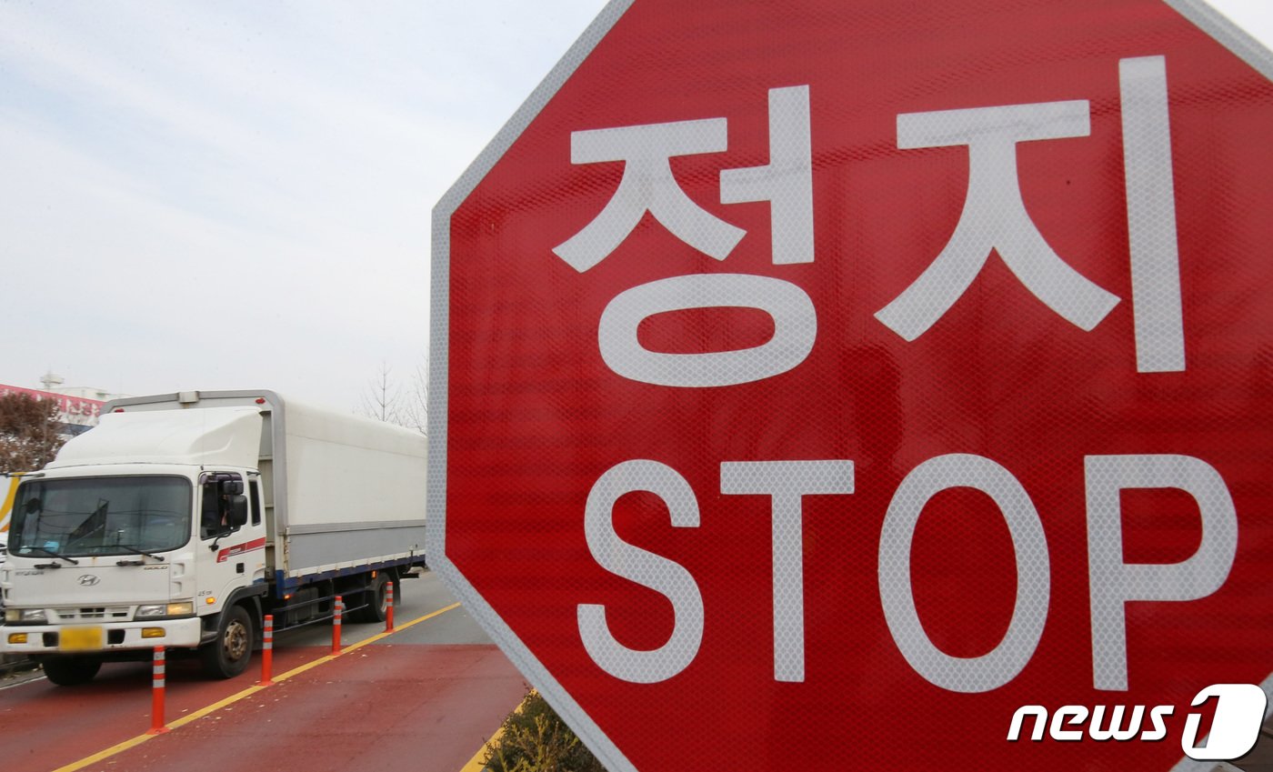 민주노총 공공운수노조화물연대가 총파업에 돌입한 24일 대전 대덕우체국네거리에서 열린 대전지부조합원 출정식 옆으로 화물트럭이 지나고 있다. 2022.11.24/뉴스1 ⓒ News1 김기태 기자