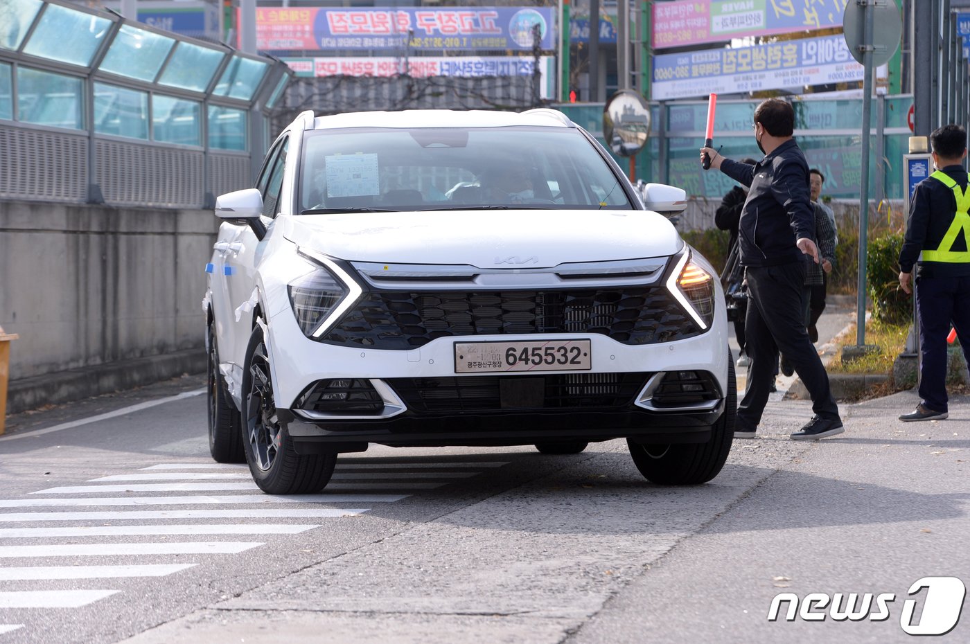 민주노총 전국공공운수노동조합 화물연대본부의 파업 2일차인 25일 오전 광주 서구 광천동 기아 오토랜드 광주공장에서 협력업체 운송사인 글로비스 직원들이 임시번호판과 임시운행 허가증을 발급받은 완성차를 광산구 평동공단 출하장과 장성 물류센터로 직접 옮기고 있다.  /뉴스1 ⓒ News1 이승현 기자