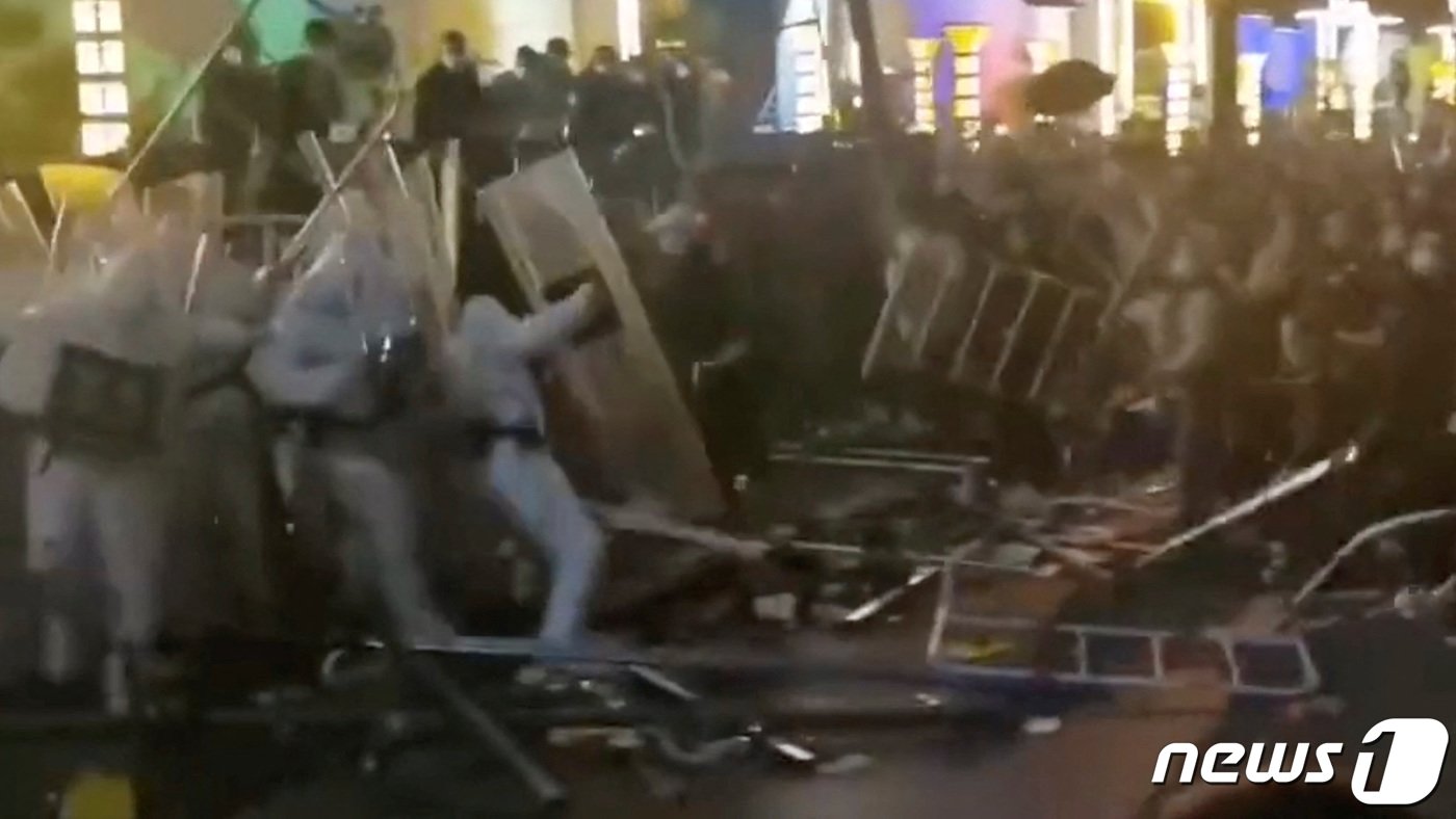 본문 이미지 - 세계 최대 규모 아이폰 생산지인 중국 정저우의 폭스콘 공장에서 근로자들이 임금 체불과 코로나19 방역에 항의하는 시위를 벌이며 보안요원과 충돌을 하고 있다. ⓒ 로이터=뉴스1 ⓒ News1 우동명 기자