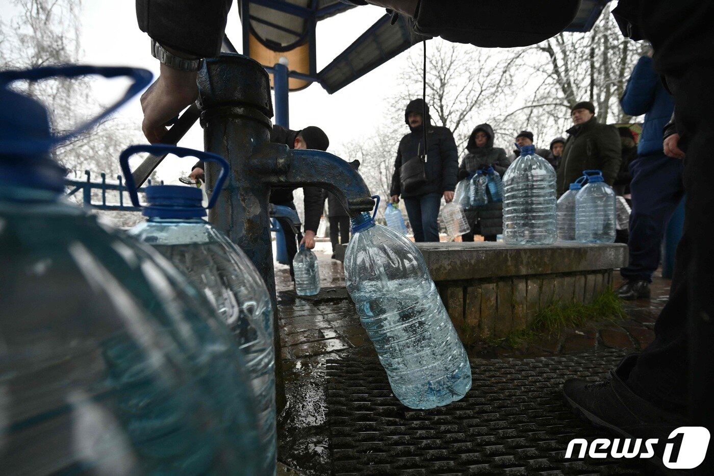 본문 이미지 - 24일(현지시간) 러시아군의 폭격으로 우크라이나 전역이 정전 및 단수된 가운데 키이우 시민들이 물을 얻기 위해 생수통을 들고 공원 급수대에 줄을 서 있다. 22.11.24 ⓒ AFP=뉴스1 ⓒ News1 김예슬 기자