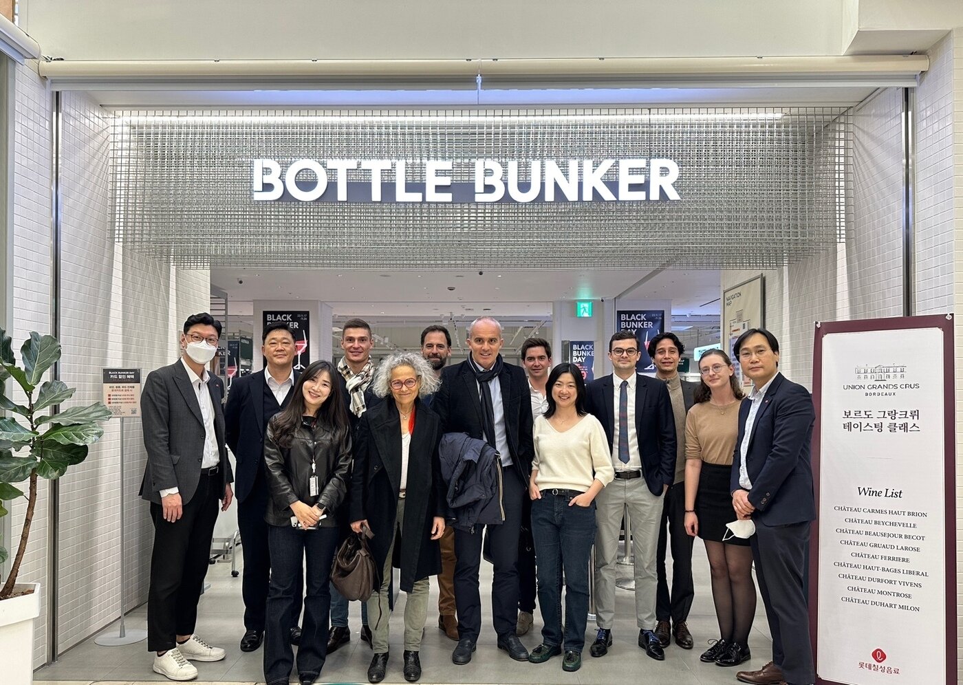 본문 이미지 - 서울 송파구에 위치한 보틀벙커 매장 앞에서 '보르도 그랑 크뤼 연합' 소속 와이너리 대표들과 보틀벙커 관계자들의 모습.(롯데쇼핑 제공)