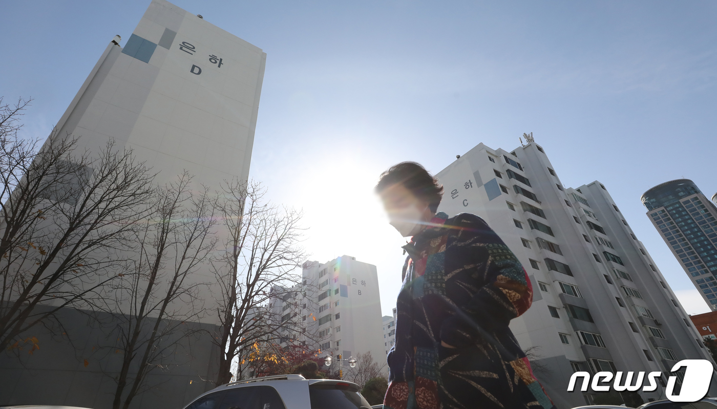 (서울=뉴스1) 장수영 기자 = 27일 서울 영등포구 여의도에 위치한 은하 아파트 앞으로 시민들이 지나가고 있다.영등포구청 등에 따르면 지난 1974년에 준공돼 재건축을 추진중인 …