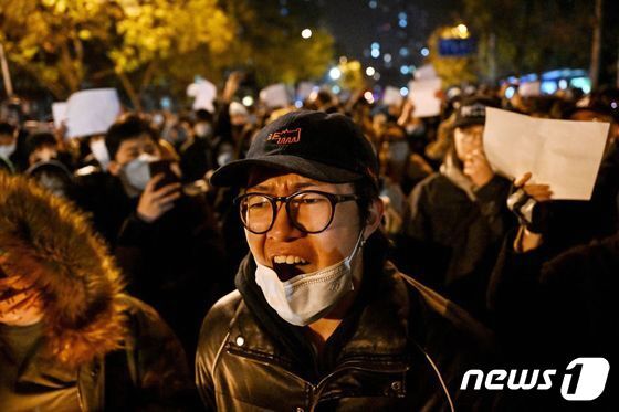 28일 중국 베이징에서 정부의 고강도 제로 코로나19 봉쇄 정책에 항의하고 우루무치 화재 희생자를 추모하는 시민이 “봉쇄 해제하라” “시진핑 물러나라” 는 구호를 외치며 밤샘 시위를 하고 있다. © AFP=뉴스1 © News1 우동명 기자