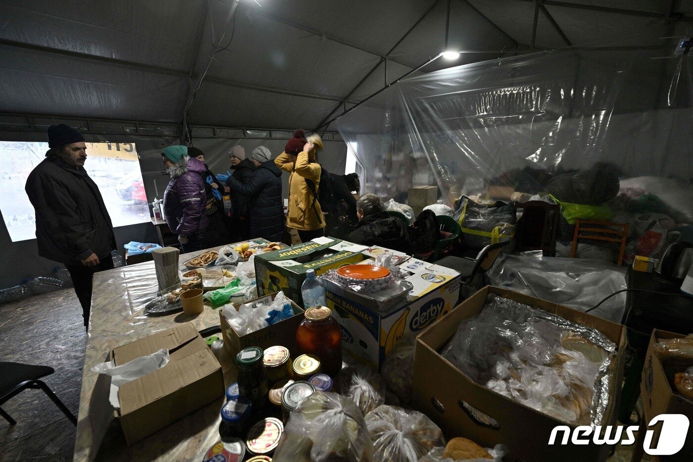 본문 이미지 - 28일(현지시간) 우크라이나 수도 키이우 외곽 우쉬고로드에 위치한 한 피난 시설. 이곳을 찾은 현지 주민들은 따뜻한 음료를 마시거나 추위로부터 몸을 녹이고 있다. 전자기기 충전도 가능하다고 한다. 최근 우크라이나에는 최저 기온이 영하권으로 떨어지면서 본격 겨울 추위가 찾아왔다. 그럼에도 러시아는 우크라이나 주요 에너지 시설 등에 공습을 거듭하고 있다. 2022.11.28 ⓒ AFP=뉴스1 ⓒ News1 정윤미 기자