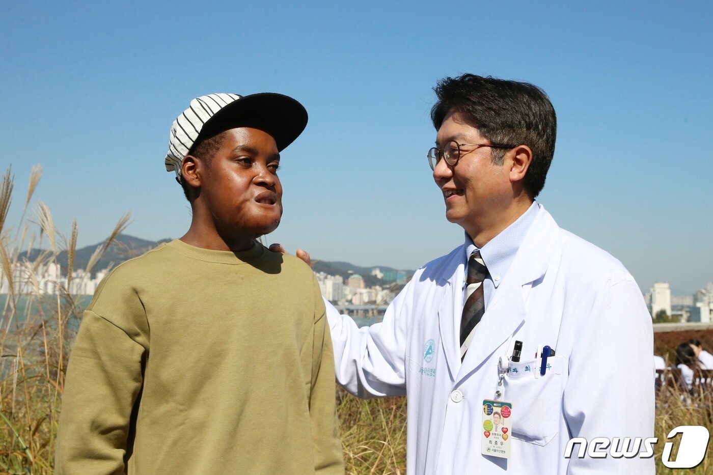 본문 이미지 - 한국을 찾아 얼굴 크기만 한 종양을 성공적으로 치료받은 플란지(왼쪽)에게 수술을 집도한 최종우 서울아산병원 성형외과 교수가 귀국을 앞두고 덕담을 건네고 있다. (아산병원 제공)