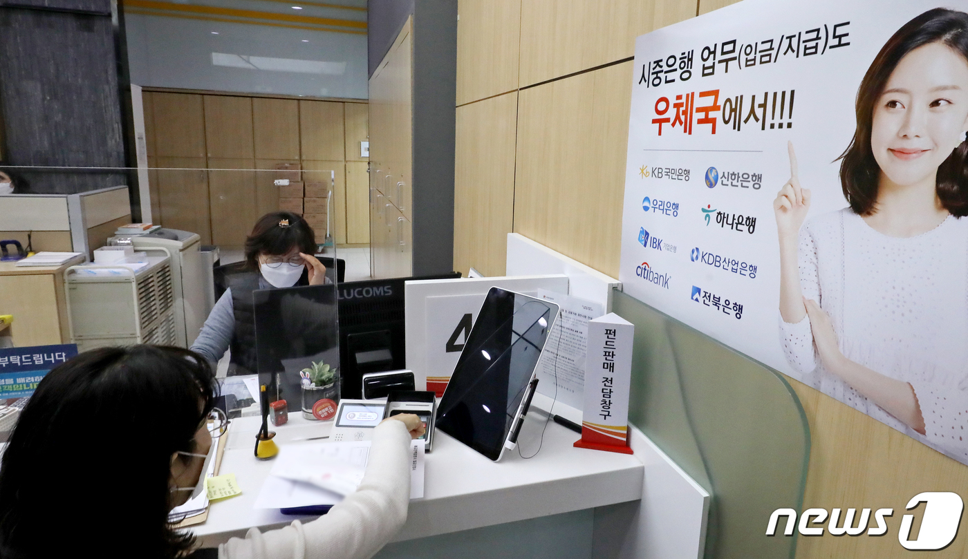 (서울=뉴스1) 장수영 기자 = 30일 서울 중구 서울중앙우체국 창구에 시중은행 입·출금 업무 안내 홍보물이 부착돼 있다.우정사업본부는 오늘부터 별도의 수수료 없이 국민·신한·우리 …