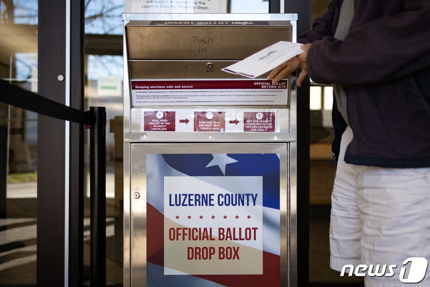 본문 이미지 - 미국 펜실베이니아주 북동부 윌크스배러에 마련된 우편투표함에 한 남성이 투표용지를 넣고 있다. 2022.11.03 ⓒ 로이터=뉴스1