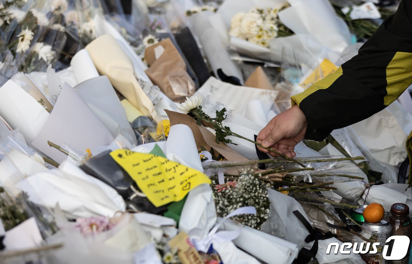 8일 오후 서울 용산구 이태원역 1번 출구에 마련된 이태원 참사 희생자 추모공간에서 한 시민이 국화꽃을 놓고 있다. 2022.11.8/뉴스1 ⓒ News1 이재명 기자