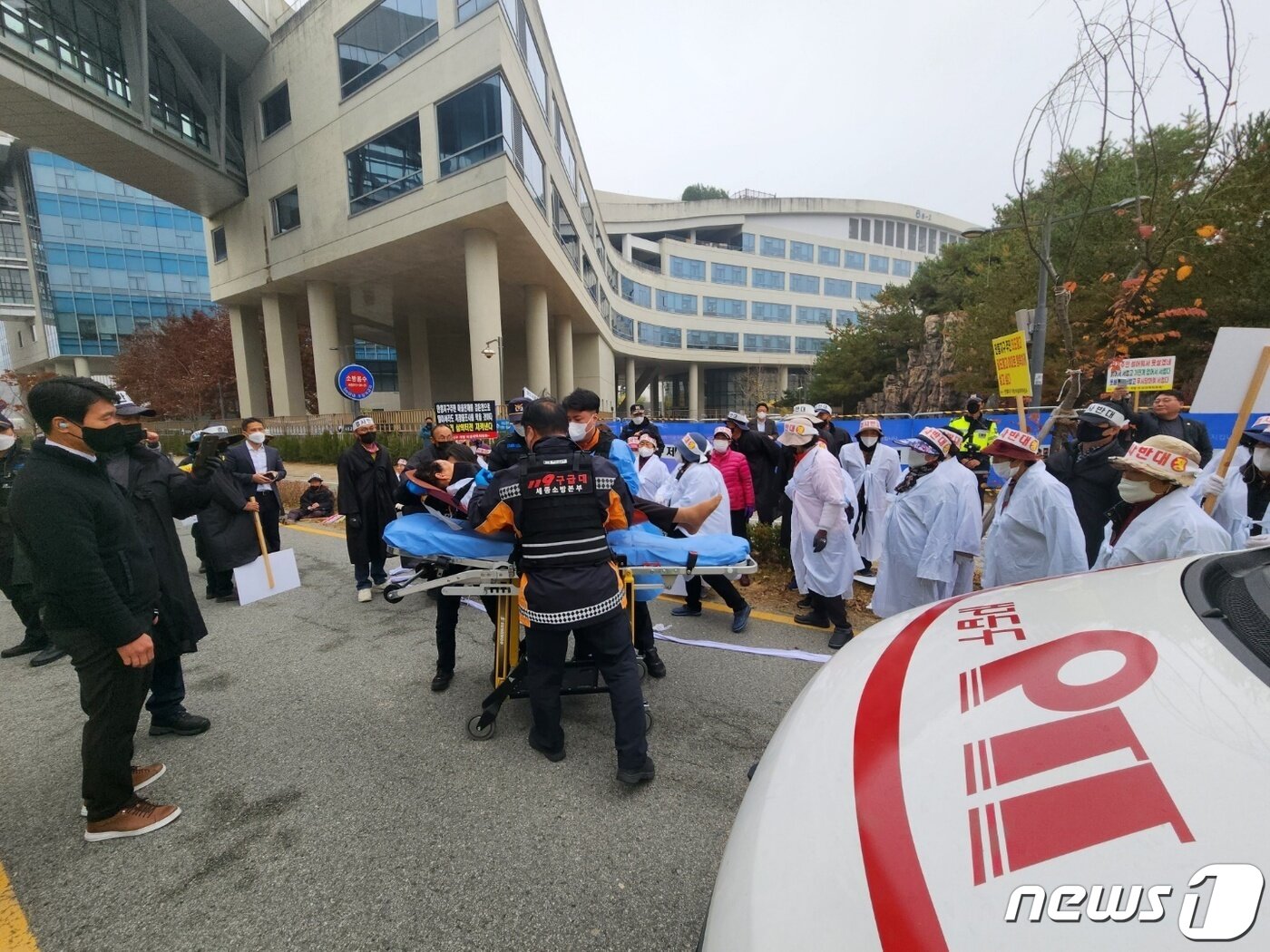 본문 이미지 - 전남 여수 만흥동 평촌마을 주민 100여명이 9일 세종시 국토교통부를 찾아 만흥지구 택지개발 사업 전면 철회를 촉구하며 삭발 투쟁을 펼치던중 실신한 주민 1명이 구급차로 이송되고 있다. (독자 제공) 2022.11.9/뉴스1 ⓒ News1