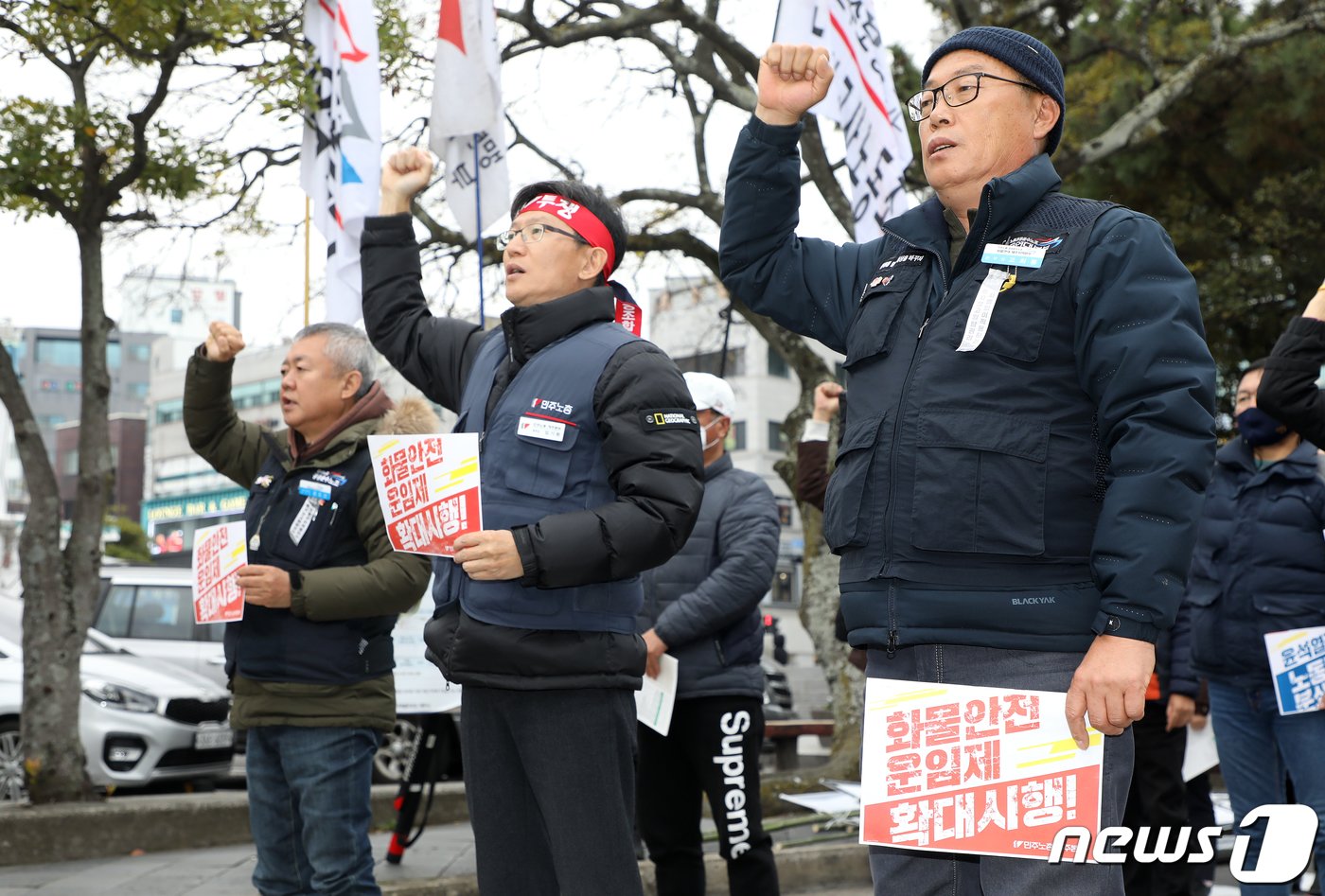 문도선 전국민주노동조합총연맹 공공운수노조 제주지역본부장&#40;왼쪽부터&#41;과 임기환 민주노총 제주지역본부장, 고희봉 민주노총 공공운수노조 화물연대본부 제주지역본부장이 10일 오후 제주시청 앞에서 열린 &#39;2022 제주민중민주민생대회&#39;에서 정부를 향해 안전운임제 확대 등을 촉구하고 있다.2022.12.10/뉴스1 ⓒ News1 오미란 기자