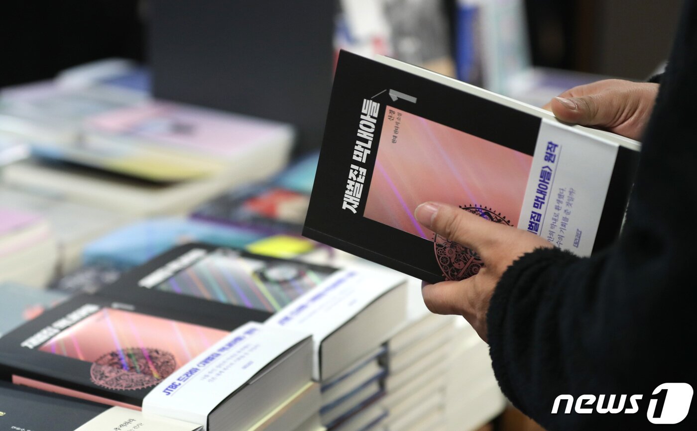 본문 이미지 - 드라마 '재벌집 막내 아들'이 시청률 20%를 넘기며 인기몰이를 하는 가운데 12일 오후 서울 교보문고 광화문점에서 한 시민이 '재벌집 막내 아들' 원작 단행본을 집어들고 있다. 2022.12.12/뉴스1 ⓒ News1 구윤성 기자