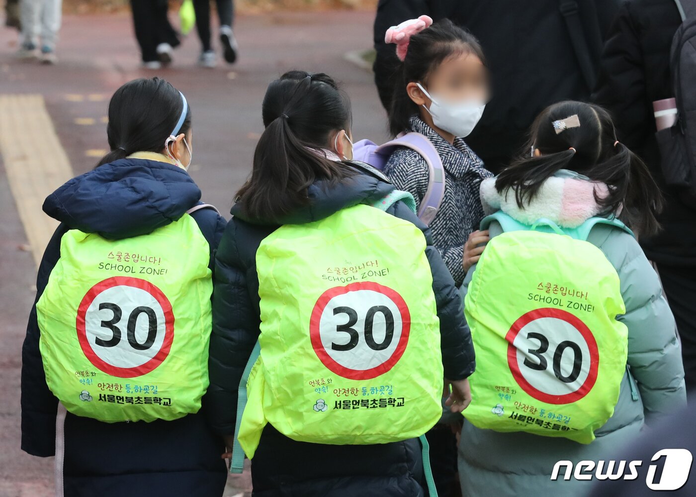 본문 이미지 - 어린이보호구역(스쿨존)에서 음주 운전 차량에 치어 초등학생이 숨진 가운데 13일 서울 강남구 언북초등학교에서 학생들이 '스쿨존 입니다' 메시지가 적힌 안전 가방을 메고 등교하고 있다. 2022.12.13/뉴스1 ⓒ News1 송원영 기자