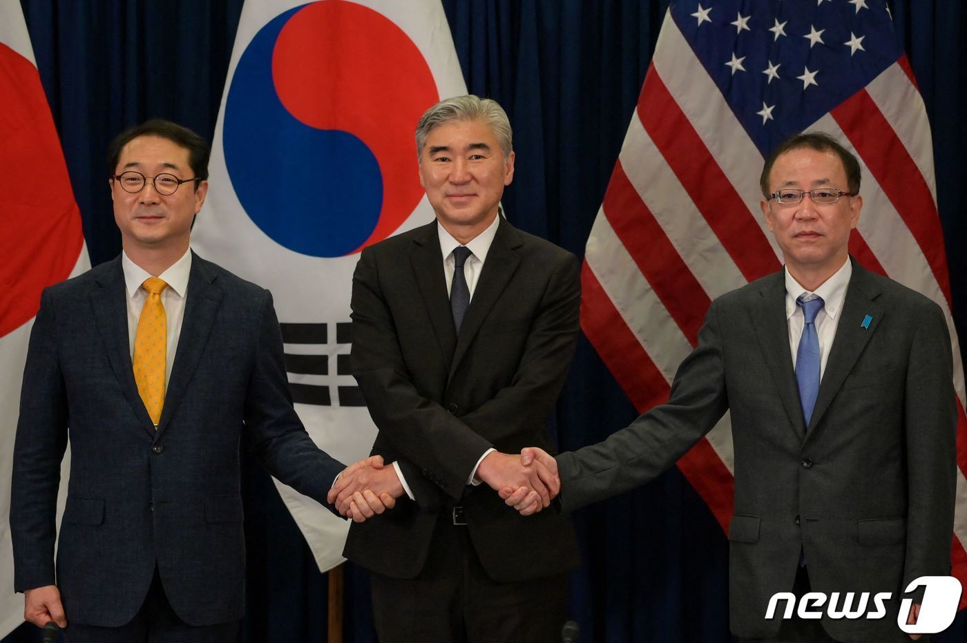 본문 이미지 - 김건 외교부 한반도평화교섭본부장과 성 김 미 국무부 대북특별대표, 후나코시 다케히로 일본 외무성 아시아·대양주국장(왼쪽부터)이 12월13일 인도네시아 자카르타 주재 미국 대사관에서 열린 한미일 북핵수석대표 협의에 앞서 악수하며 기념사진을 찍고 있다. 2022. 12. 13. ⓒ AFP=뉴스1