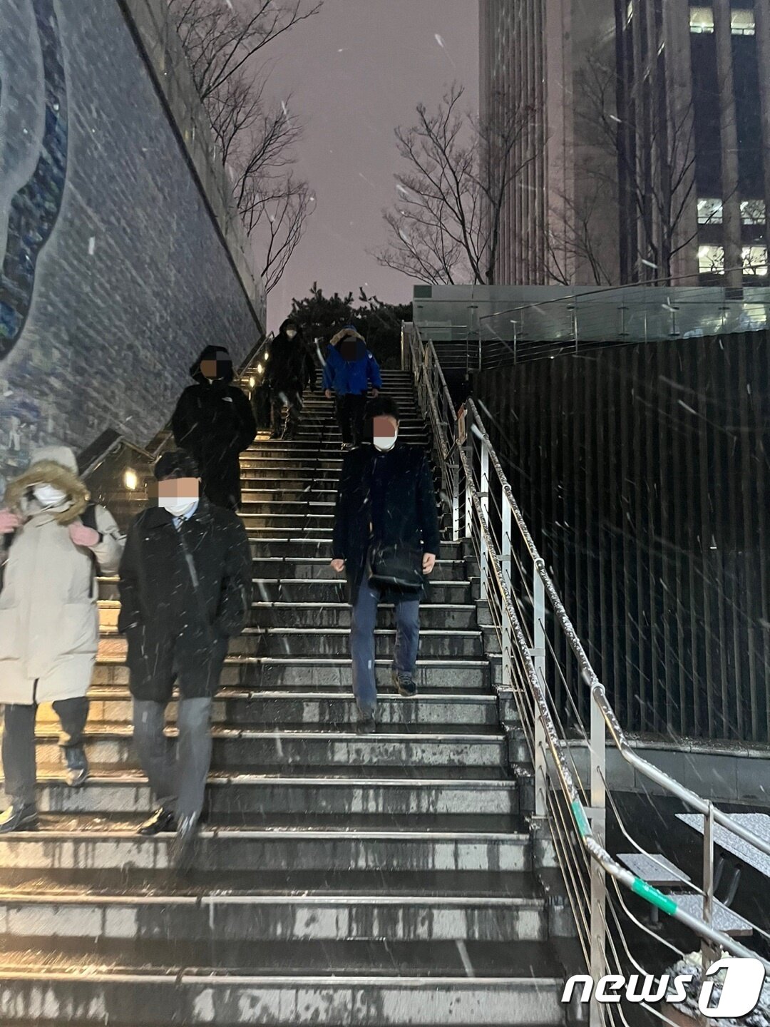 본문 이미지 - 눈내리는 퇴근길 시청역 지하철 입구로 들어가는 시민 모습