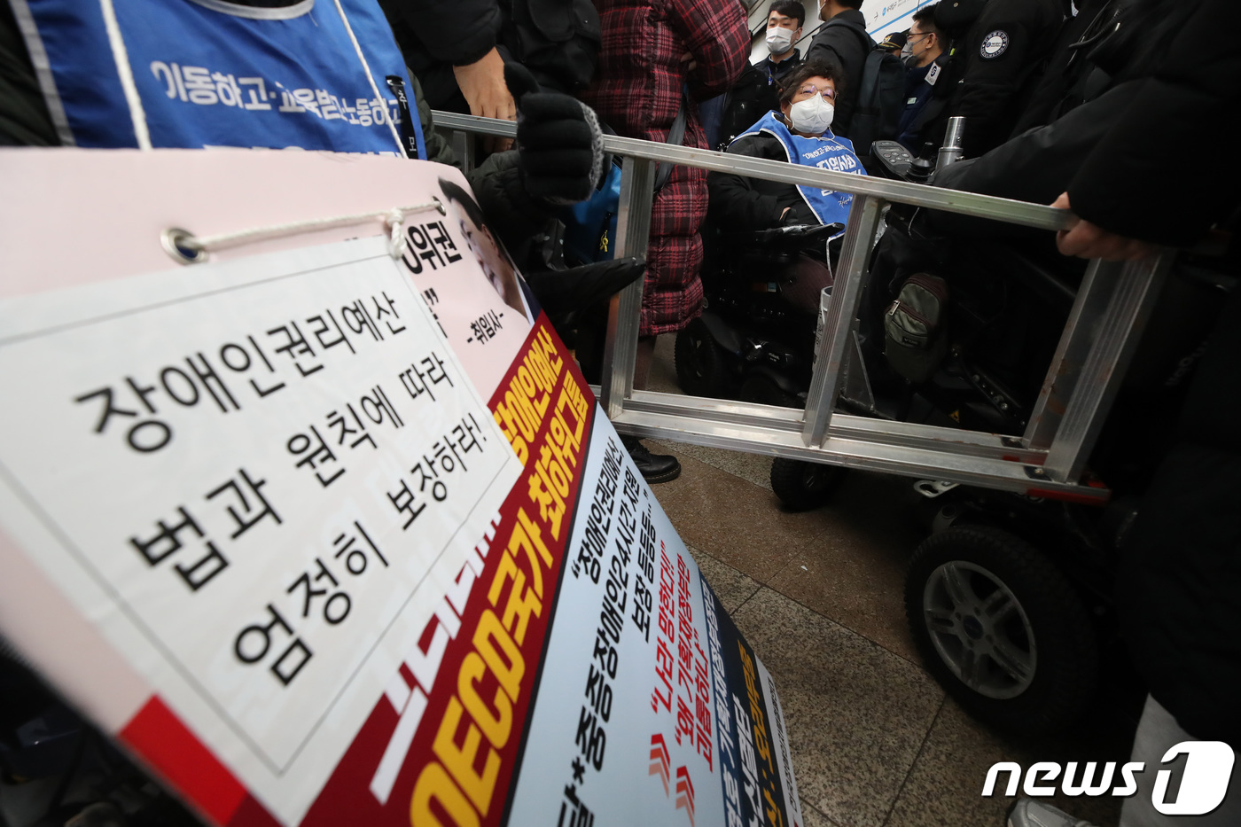 (서울=뉴스1) 김민지 기자 = 전국장애인차별철폐연대(전장연) 회원들이 14일 오전 서울 용산구 삼각지역에서 지하철 탑승 시위 도중 사다리 반입 시도로 경찰과 갈등을 빚고 있다.이 …