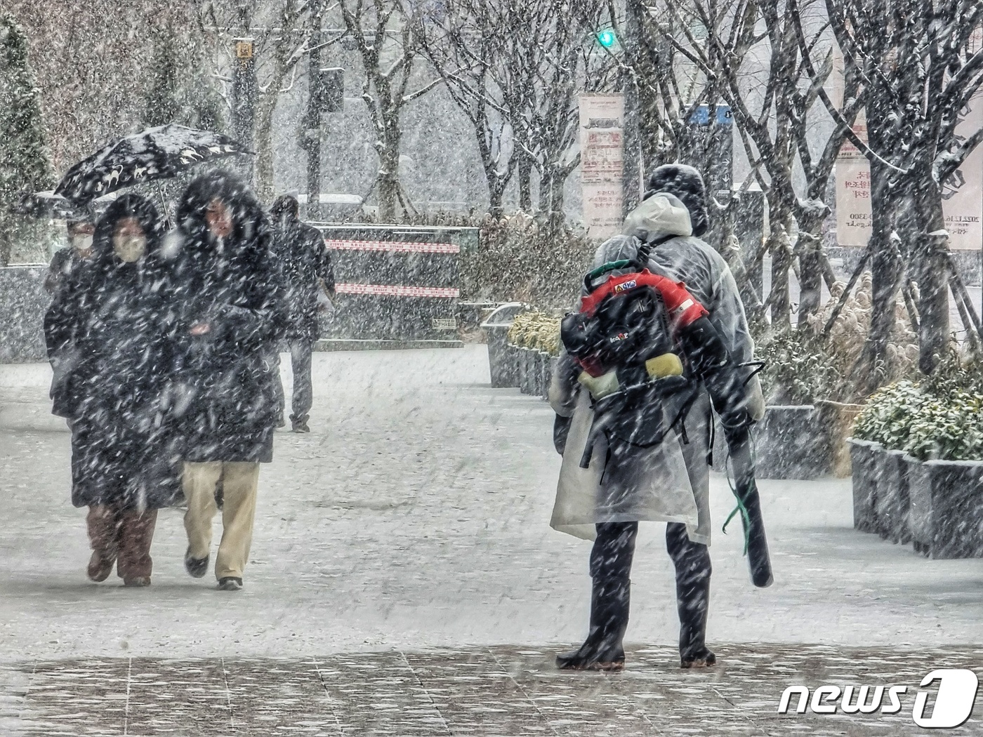 (서울=뉴스1) 황덕현 기자 = 15일 오후 서울 중구 서울시청 인근에서 한 제설담당자가 휴대용 송풍기를 이용해 쌓이는 눈을 치우고 있다. 2022.12.15/뉴스1