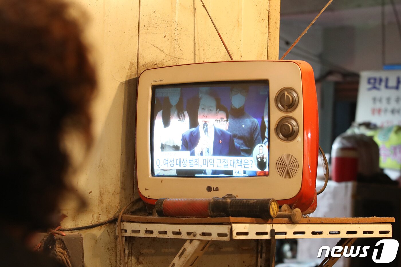 본문 이미지 - 윤석열 대통령이 15일 오후 청와대 영빈관에서 제1차 국정과제 점검회의를 주재하는 가운데 대구 중구 번개시장에서 시민들이 낡은 텔레비전에 집중해 생중계를 시청하고 있다. 2022.12.15/뉴스1 ⓒ News1 공정식 기자