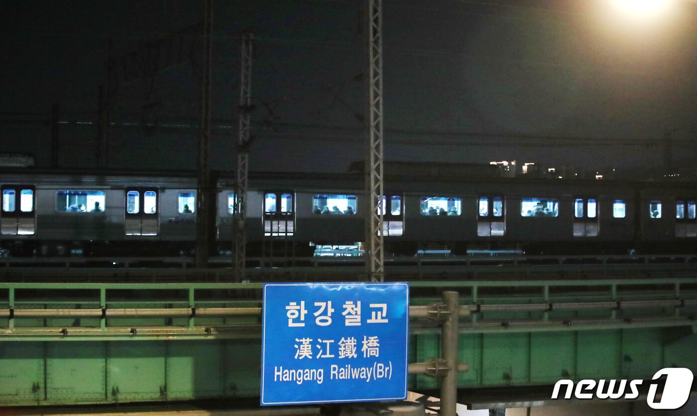 본문 이미지 - 15일 저녁 서울 지하철 1호선 열차가  한강철교 위에서 2시간 넘게 멈추는 사고가 발생했다. 견인 조치가 완료된 뒤 한강철교 위를 서행하는 1호선 열차. 2022.12.15/뉴스1 ⓒ News1 임세영 기자