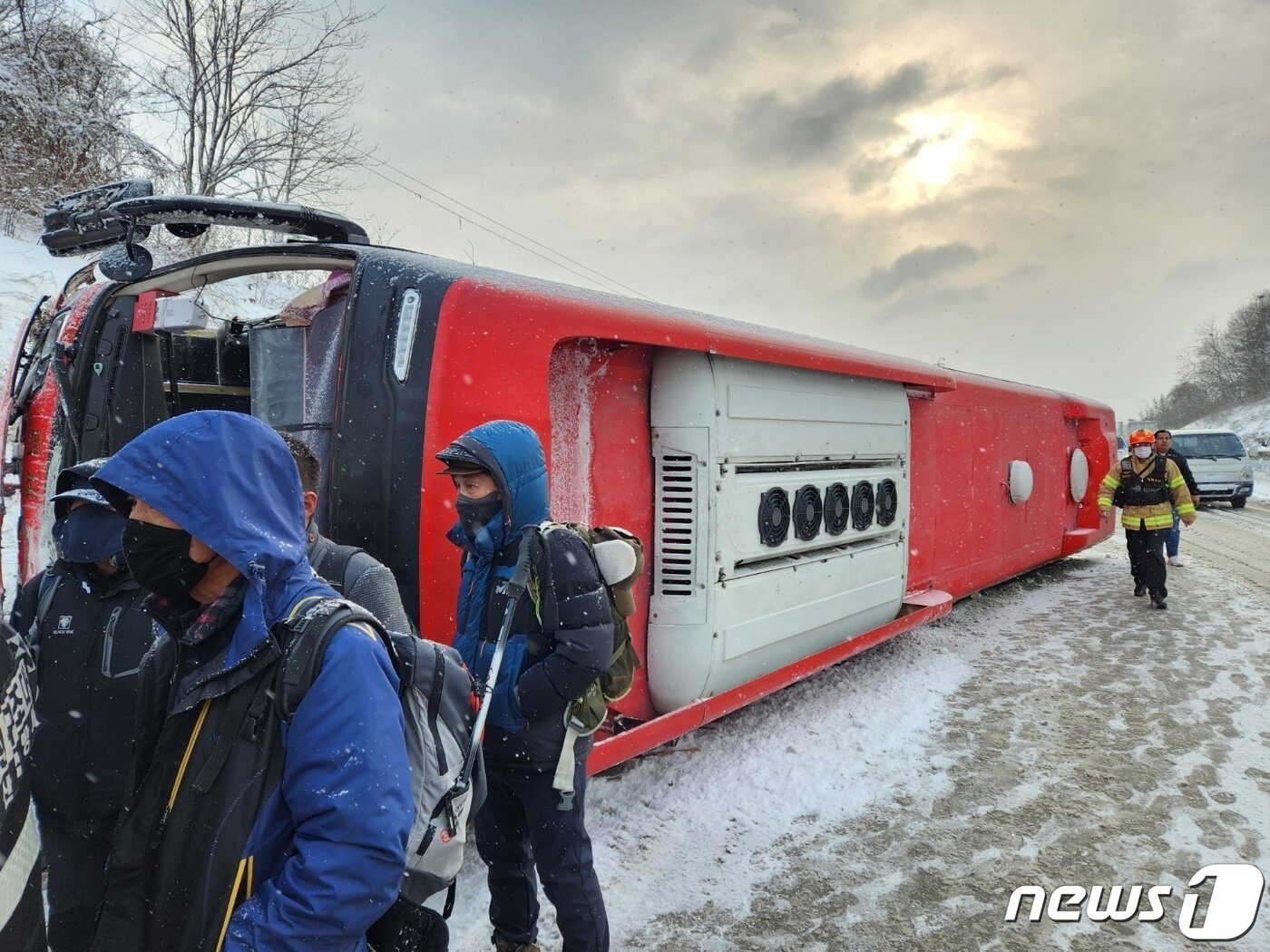 본문 이미지 - 17일 오전 9시께 대설주의보가 내려진 가운데 산행을 가려던 산악회 버스가 당진~영덕 고속도로 서산방향 예산 고덕 부근에서 승용차와 부딪히면서 옆으로 넘어졌다. 산악회원들이 소방대원들에 의해 구조돼 이동하고 있다. (충남 예산소방서 제공)/뉴스1