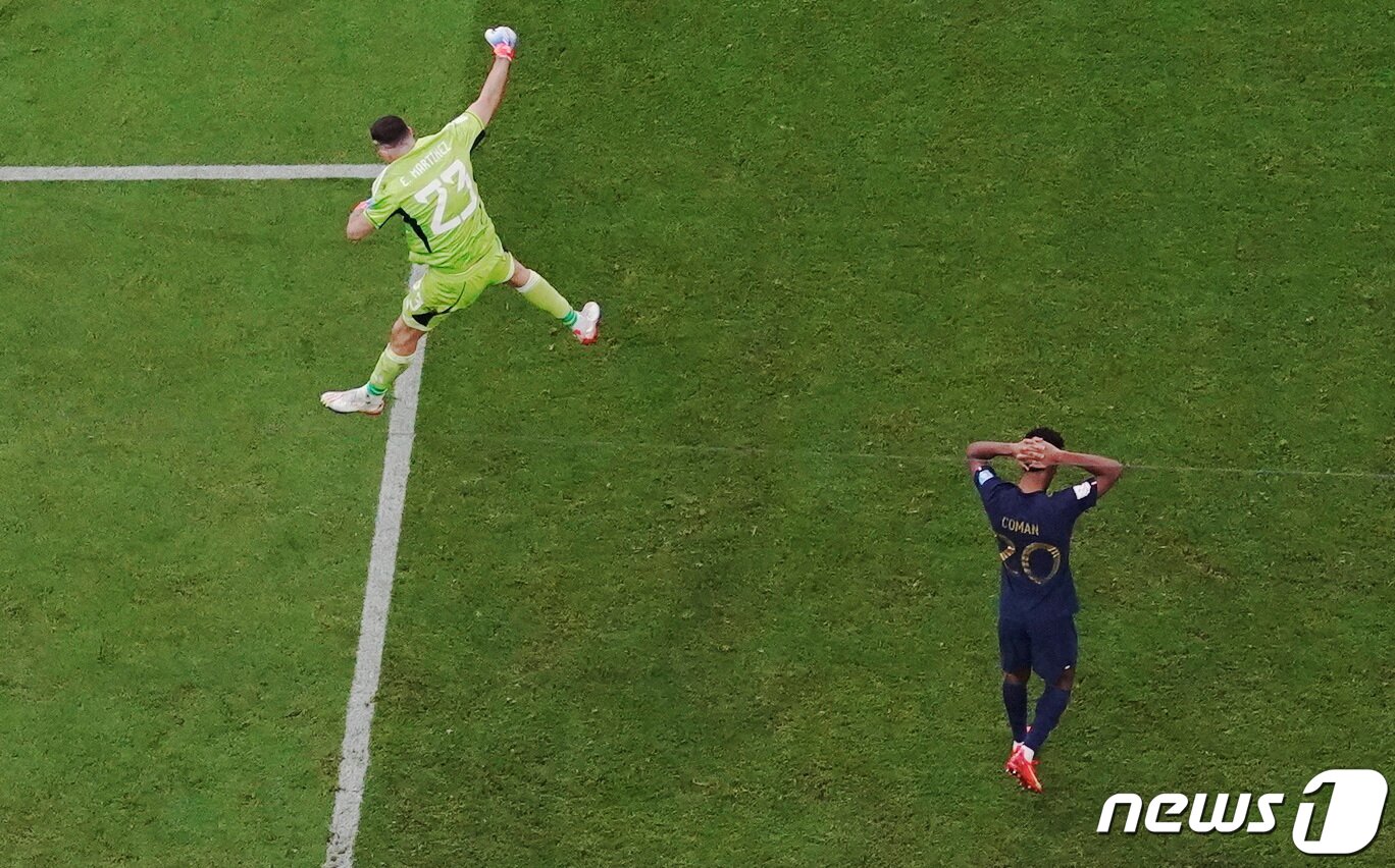 본문 이미지 - 18일(현지시간) 2022 카타르 월드컵 아르헨티나-프랑스 결승전에서 승부차기 끝에 아르헨티나가 우승컵을 들었다. 승부차기에 실축한 프랑스의 킹슬리 코망이 머리를 쥐어싸고 고개를 떨군 가운데 아르헨티나의 골키퍼 에밀리아노 마르티네스가 폴짝 뛰며 기뻐하고 있다. ⓒ 로이터=뉴스1 