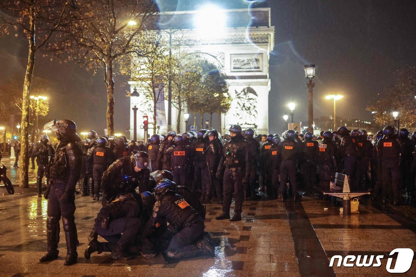 본문 이미지 - 카타르 월드컵 결승전에서 프랑스가 아르헨티나에 패한 직후 18일(현지시간) 오후 프랑스 파리 개선문 인근 샹젤리제 거리에서 한 사람이 경찰 병력에 진압되고 있다. 2022.12.18 ⓒ AFP=뉴스1 ⓒ News1 정윤미 기자