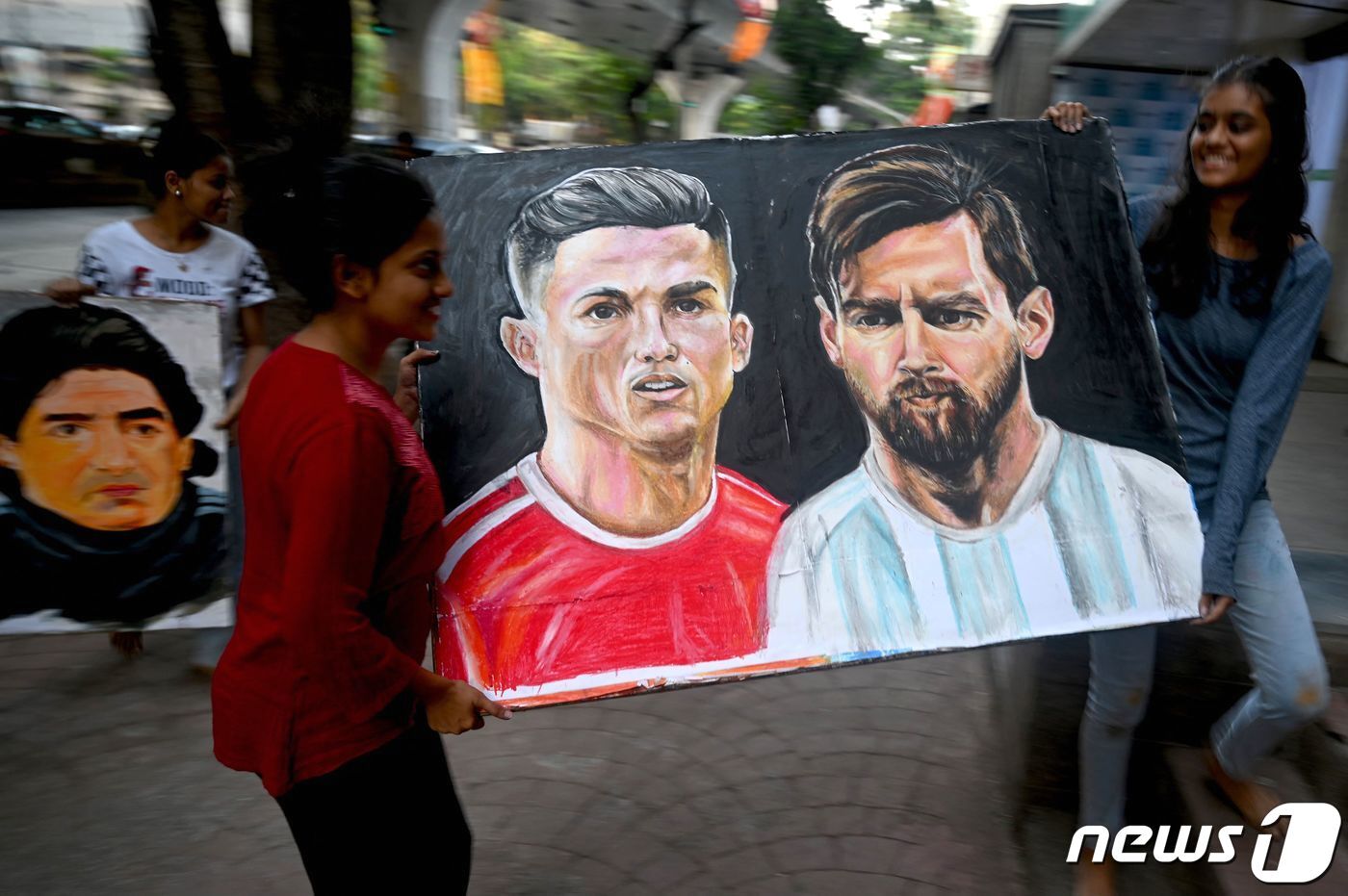 본문 이미지 - 리오넬 메시(오른쪽)와 호날두의 그림을 든 팬들 ⓒ AFP=뉴스1