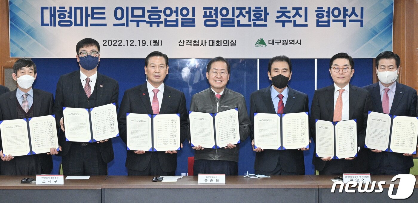 본문 이미지 - 홍준표 대구시장과 구청장·군수, 전국상인연합회 대구지회장, 한국체인스토어협회장 등 관계자들이 19일 오후 대구시청 산격청사에서 열린 '대형마트 의무휴업일 평일전환 추진 협약식'에 참석해 기념촬영을 하고 있다. (대구시 제공) 2022.12.19/뉴스1 ⓒ News1 공정식 기자