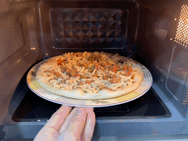 본문 이미지 - 쿠쿠전자 무회전 플랫타입 전자레인지에 냉동 피자를 넣어 조리하는 모습 ⓒ News1 이민주 기자