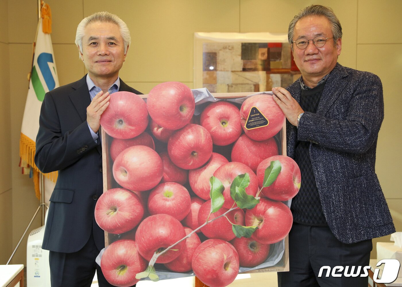 본문 이미지 - 박종복 SC제일은행장이 23일 오전 서울 종로구 SC제일은행 본점에서 뉴스1 사랑의 바자회에서 구매한 그림판화를 강호병 전무이사로부터 전달받은 후 기념촬영하고 있다. 그림판화는 사과전문작가 윤병락 화가의 사과그림 원본을 판화로 재현한 한정판 시리즈 '가을향기 19호'로 서울옥션에서 기증했다. 2022.12.23/뉴스1 ⓒ News1 김도우 기자