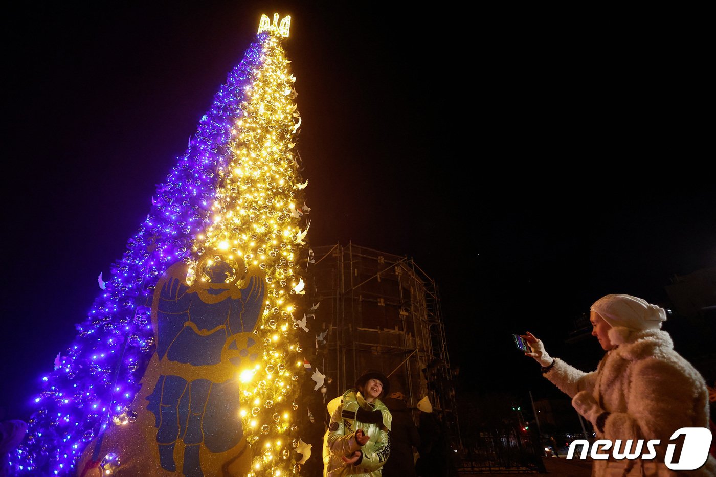 본문 이미지 - 19일&#40;현지시간&#41; 우크라이나 수도 키이우 도심 소피아 광장에 크리스마스 트리가 점등되자 시민들이 나와 기념사진을 찍고 있다. 2022. 12. 19. ⓒ 로이터=뉴스1 ⓒ News1 최서윤 기자