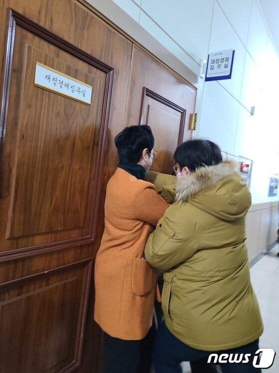 본문 이미지 - 충북 청주시청 본관동 철거에 반대하는 청주시의회 더불어민주당 의원들이 20일 4차 본회의에 참석하려는 같은 당 임정수 의원을 재정경제위원회 집무실에 데리고 간 뒤 설득하고 있다. 임 의원이 집무실을 나오려 하자 민주당 의원들이 문을 막고 있다.2022.12.20/ⓒ 뉴스1 강준식 기자