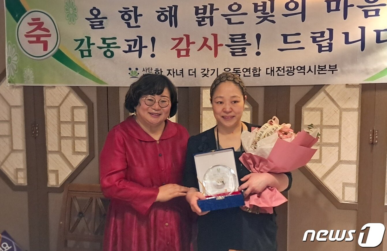 본문 이미지 - ㈔한자녀더갖기운동연합 대전본부 오국회 본부장(왼쪽)이 22일 서구 만년동에서 식당을 운영하는 이윤미씨에게 ‘애국가족 표창패’를 수여한 후 기념촬영을 하고 있다. ⓒ뉴스1 최일 기자